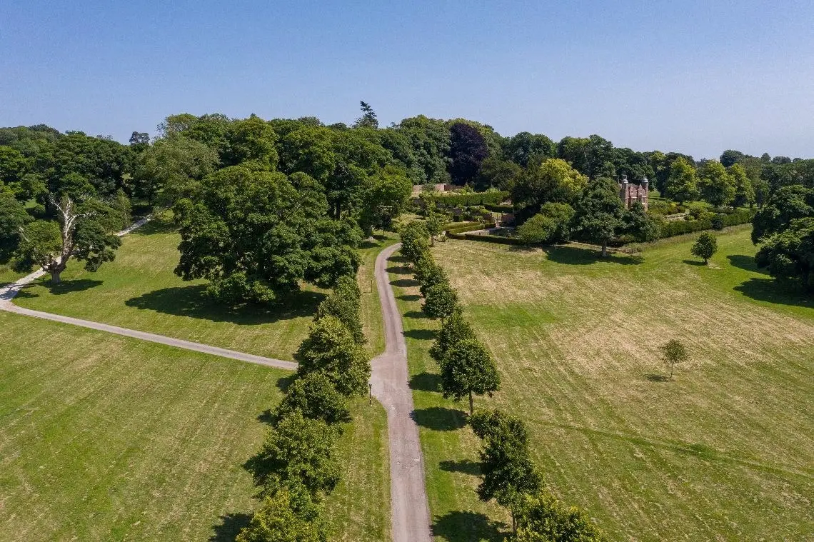 Aerial view of the tree-lined drive crossing the park towards the house