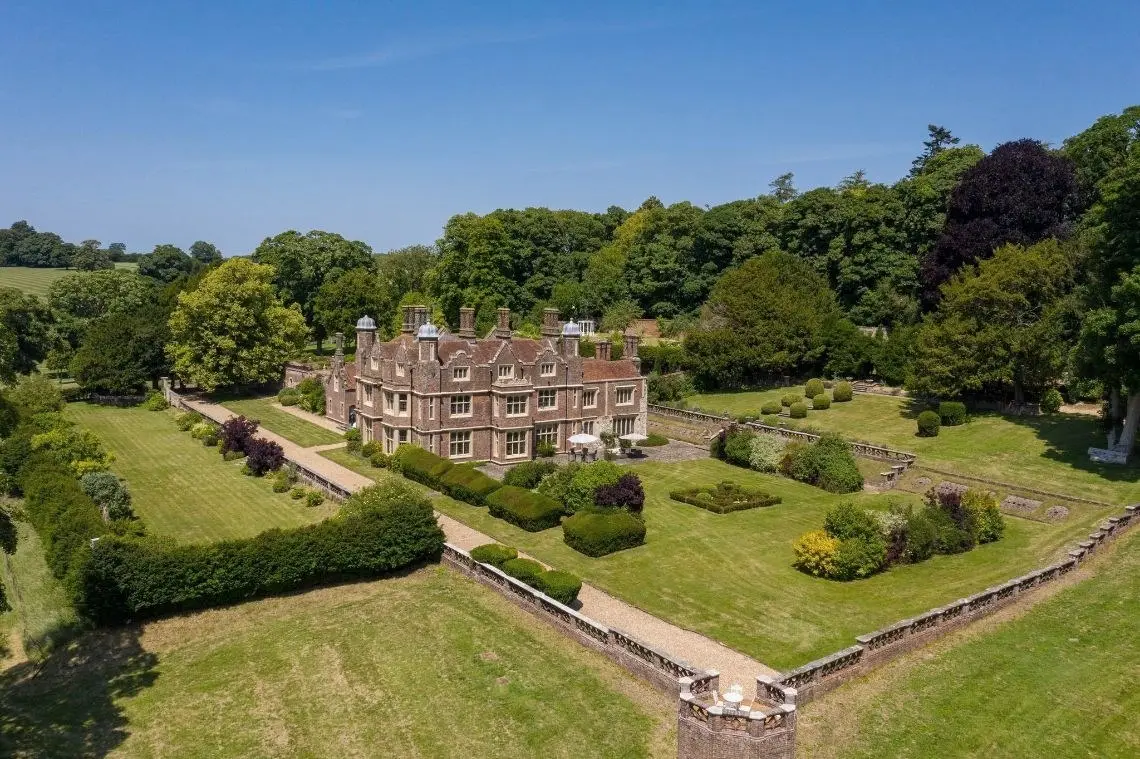 Aerial view of the house, its terraces and formal gardens, with woodland behind
