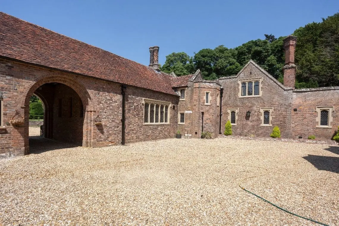 The gravel courtyard with its brick archway and service range