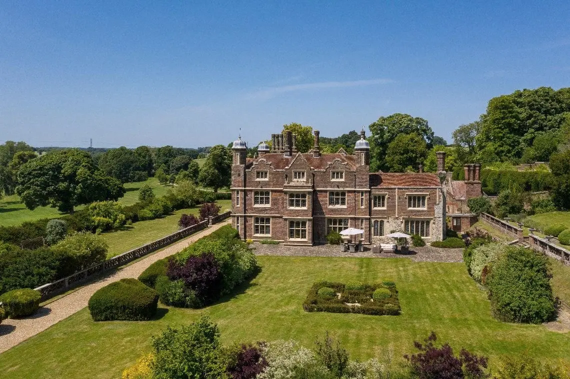 The garden front of the house seen across the lawn and formal garden