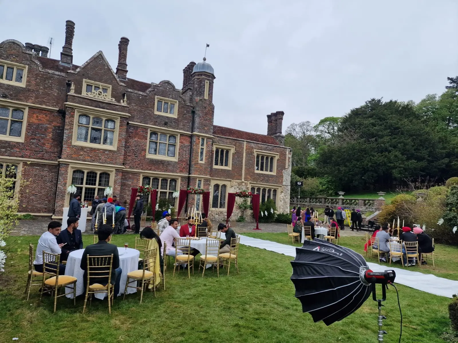 Guests at round tables on the lawn in front of the house