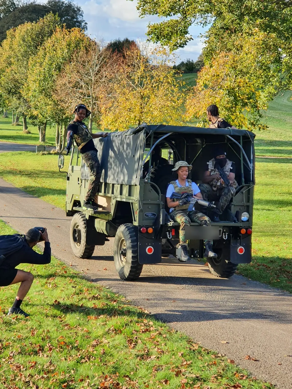 A military vehicle carrying cast along the drive through the parkland, photographed during a shoot
