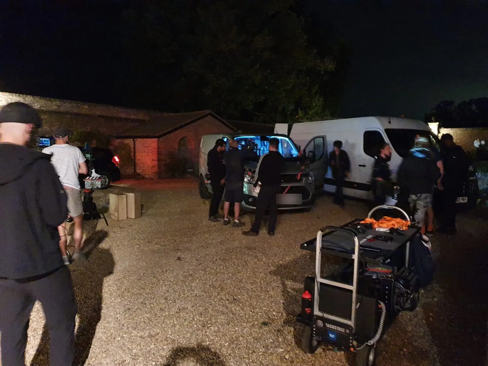 Crew vans and equipment carts at the unit base after dark